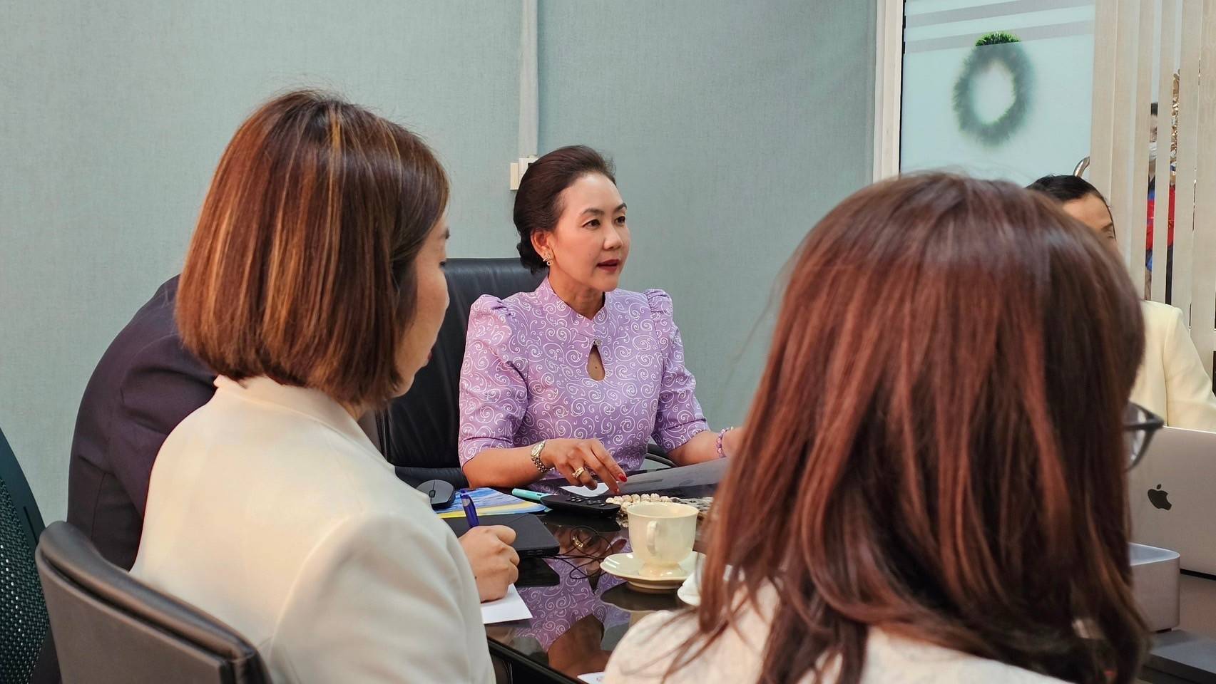 A person in a purple shirt talking to a group of women

Description automatically generated