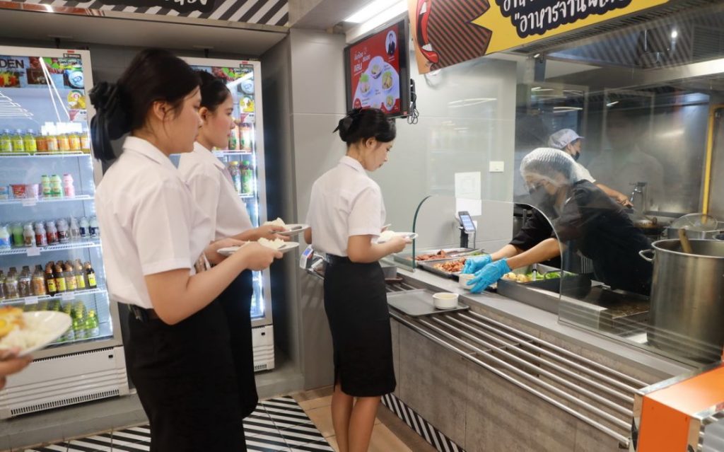 A group of women standing in a line at a food counter

AI-generated content may be incorrect.