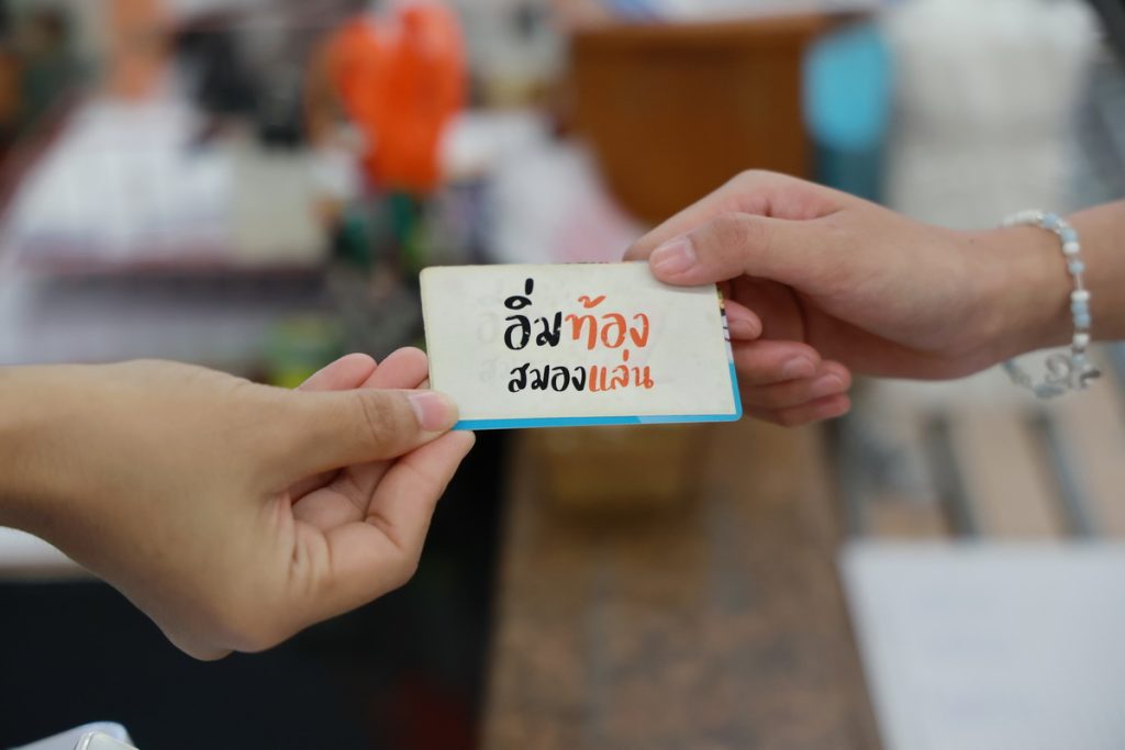 A person handing a card to another person

AI-generated content may be incorrect.