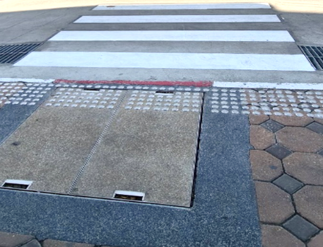 A crosswalk with a manhole cover

AI-generated content may be incorrect.
