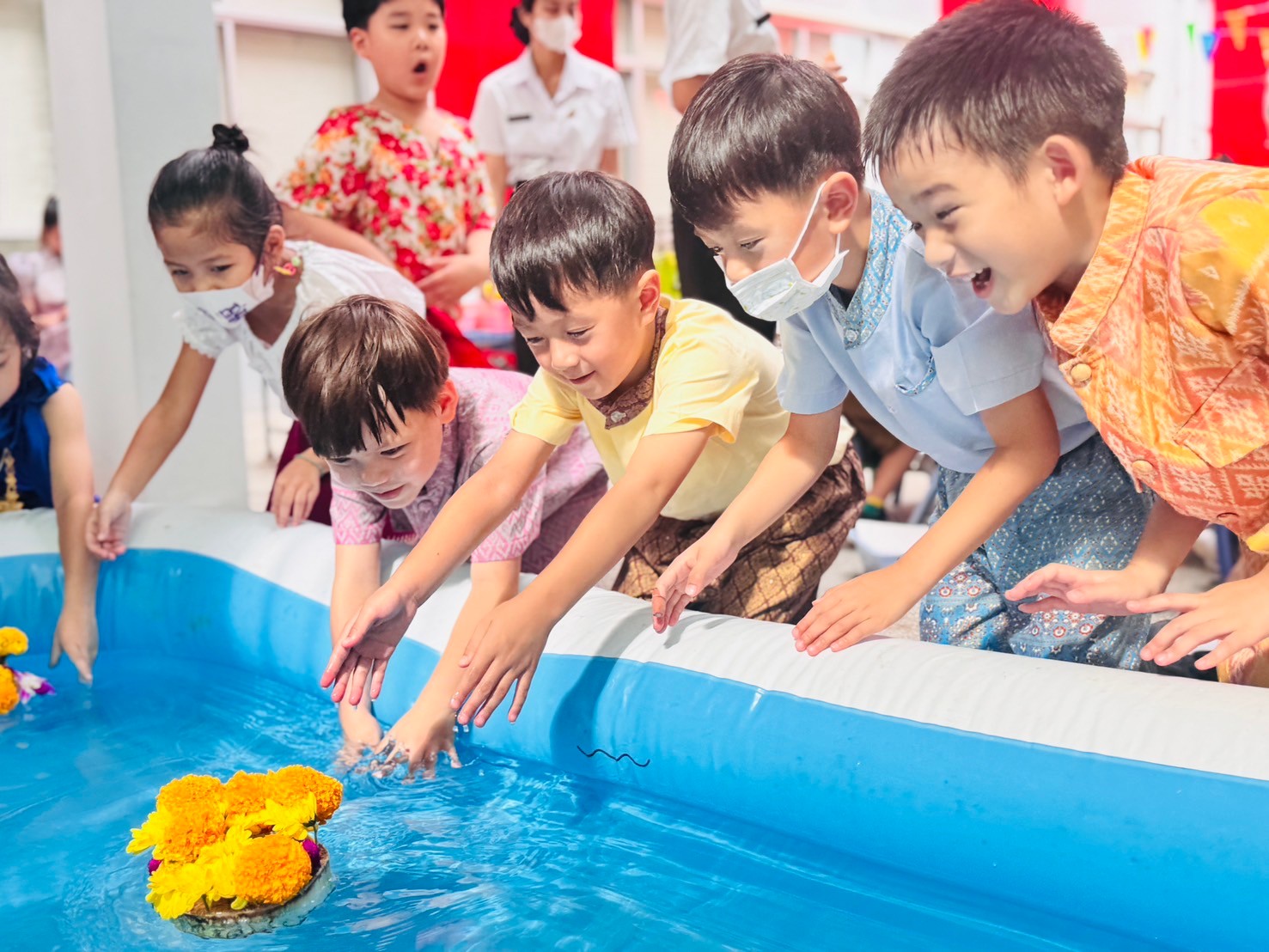 A group of children playing in a pool
Description automatically generated