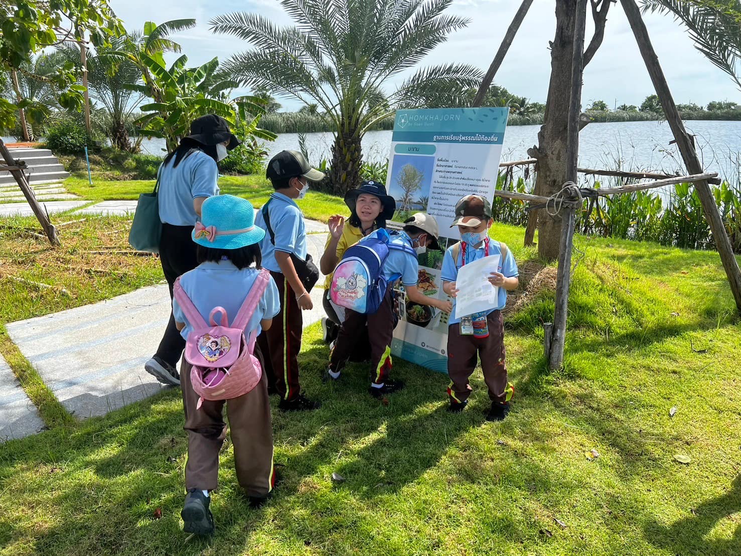 A group of kids in uniform standing in grass

Description automatically generated