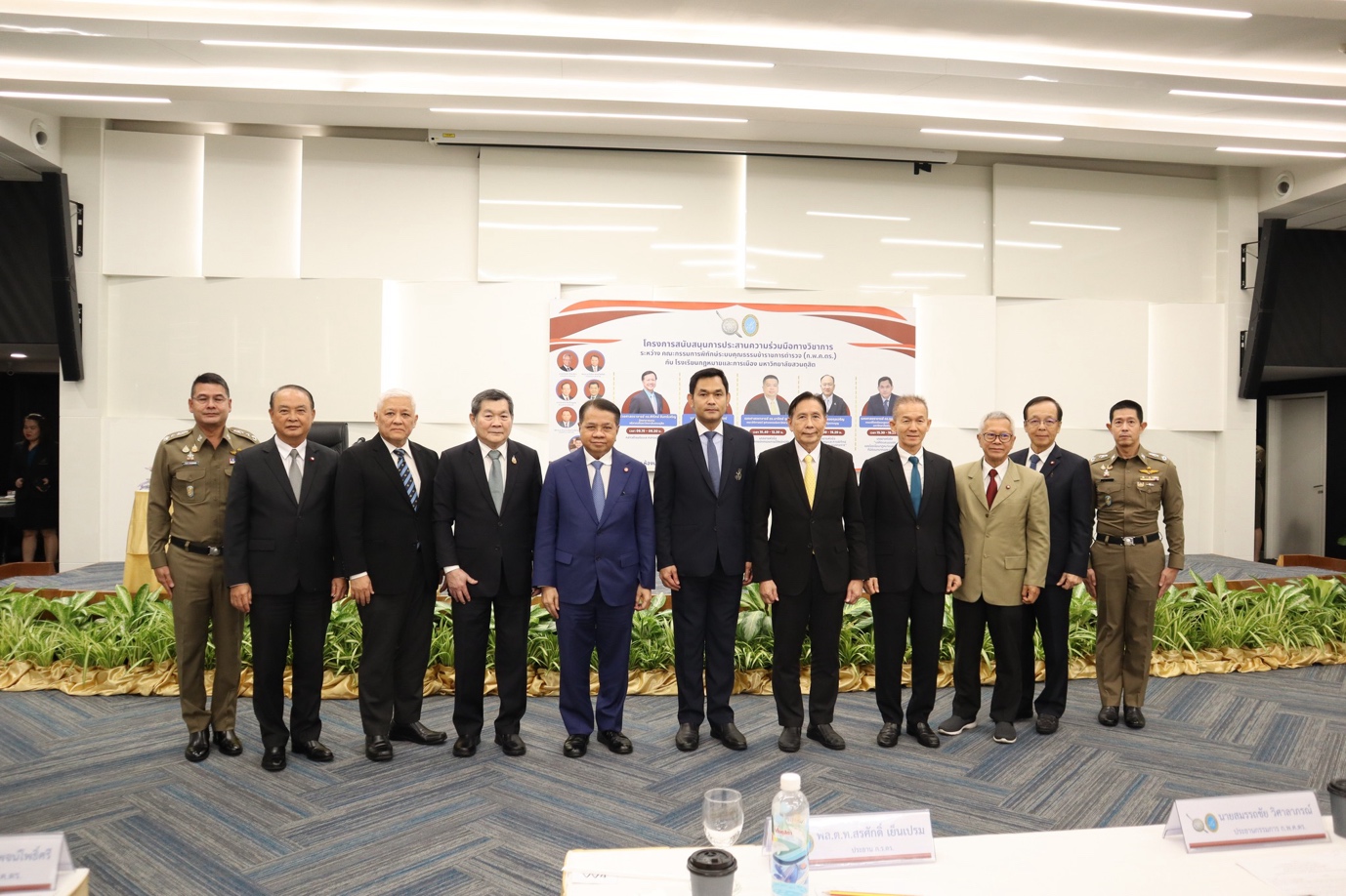 A group of men in suits standing in a room
Description automatically generated