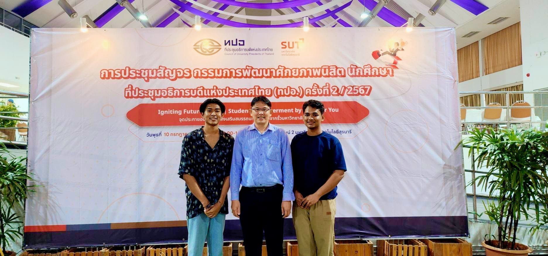 A group of men standing in front of a banner

Description automatically generated