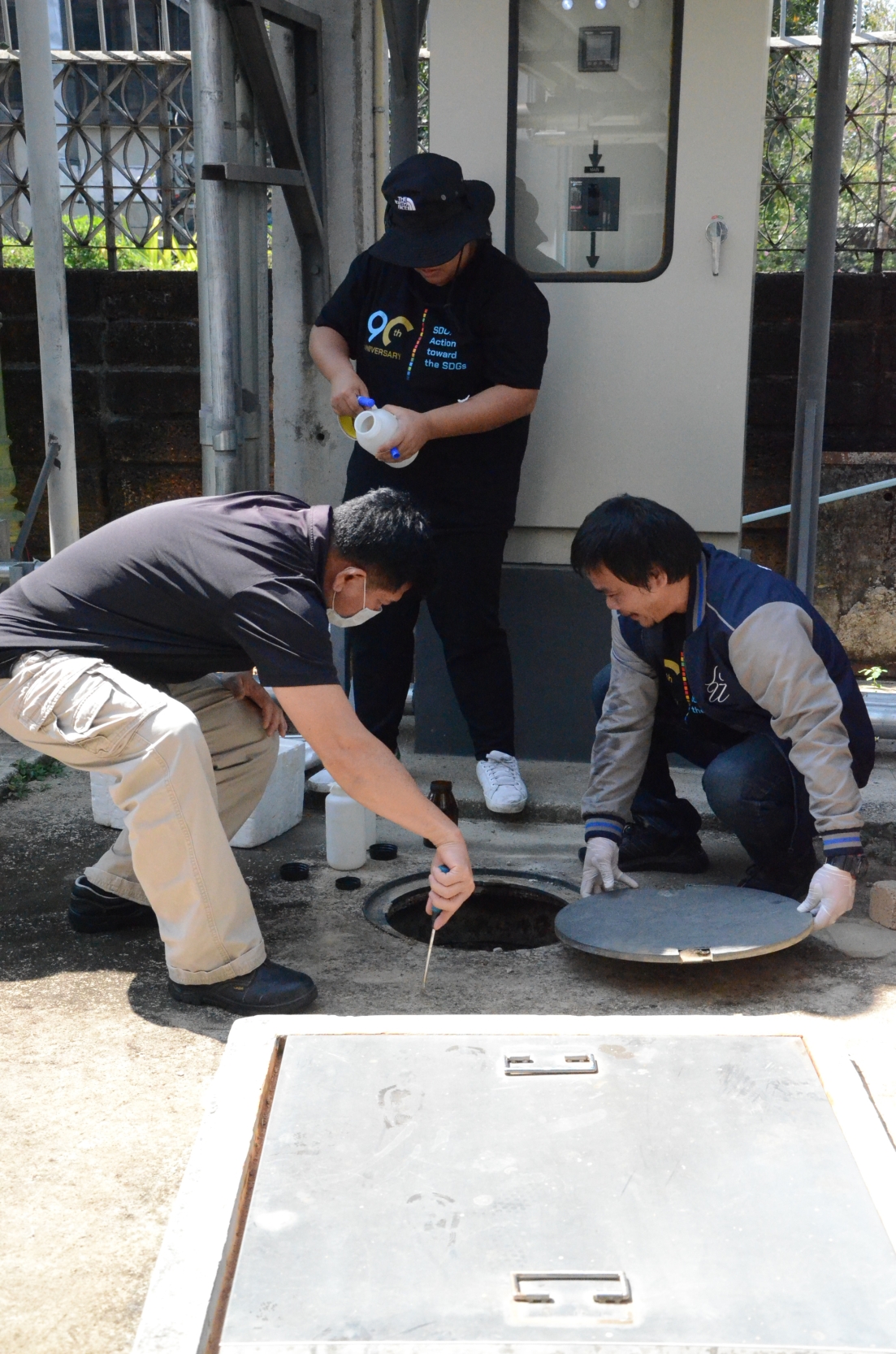 A group of men working on a sewer

Description automatically generated