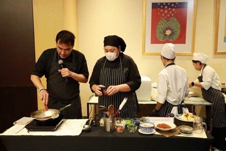 A group of people cooking in a kitchen

Description automatically generated