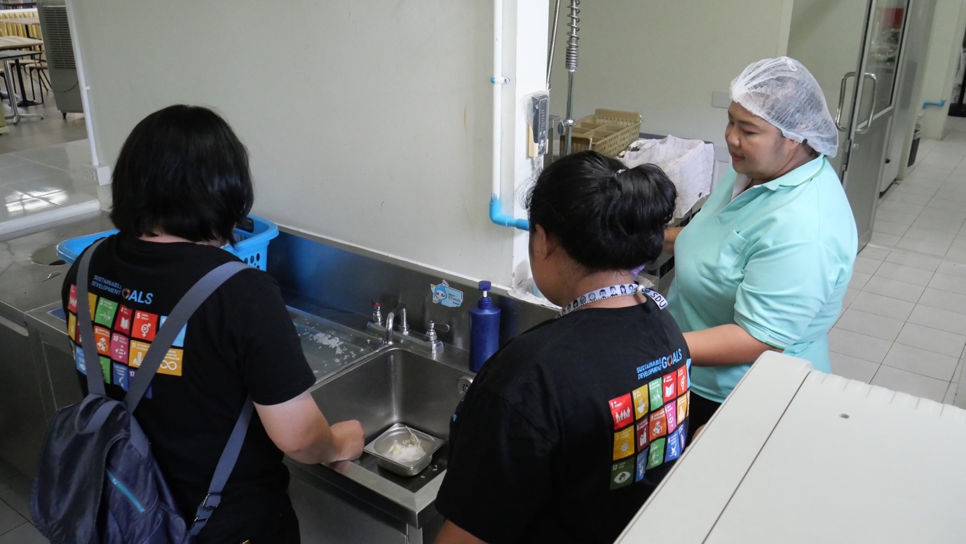 A group of people in a kitchen

Description automatically generated