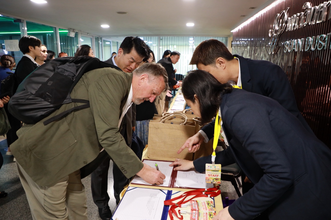 A group of people looking at a document
Description automatically generated