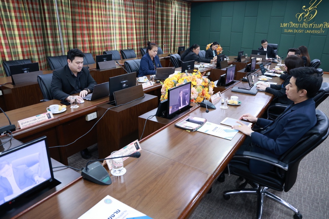 A group of people sitting at a table with laptops

Description automatically generated