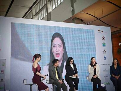 A group of people sitting on stools

Description automatically generated