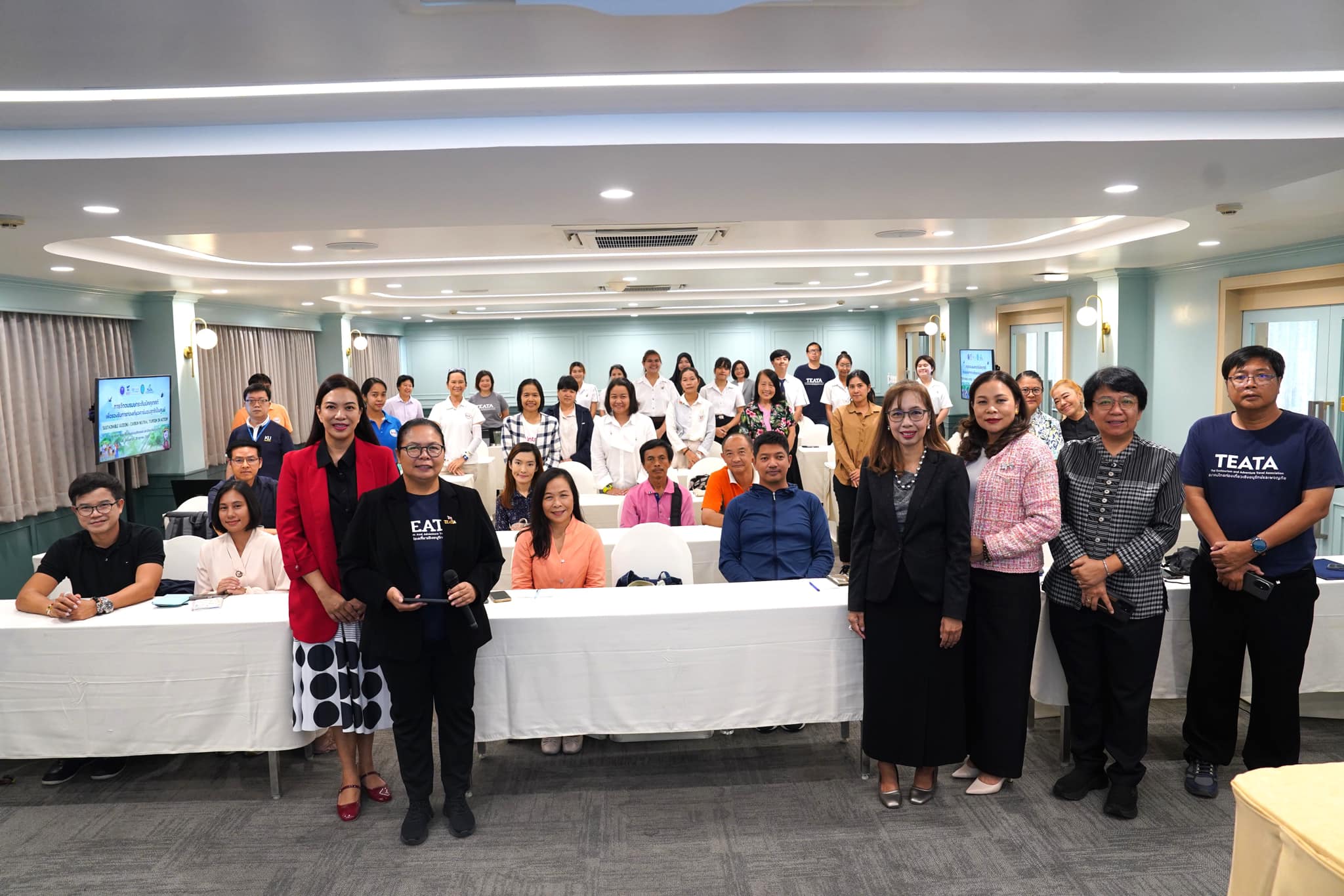 A group of people standing in a room
Description automatically generated