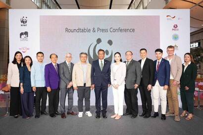 A group of people standing in front of a large screen

Description automatically generated