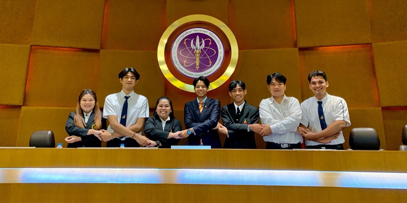 A group of people standing in front of a podium

Description automatically generated