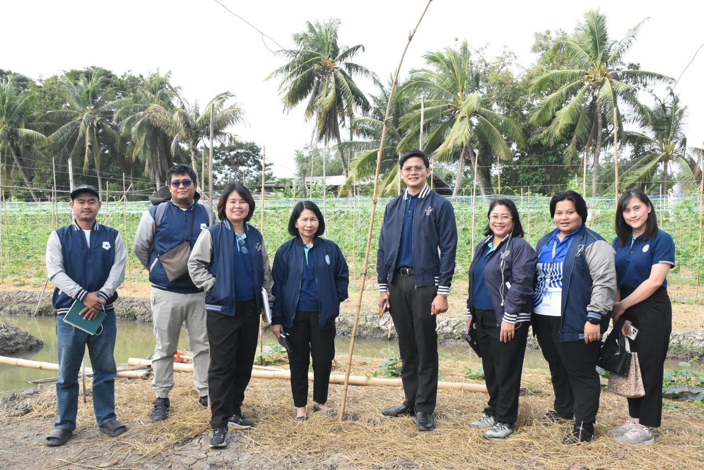 A group of people standing in front of a pond

Description automatically generated