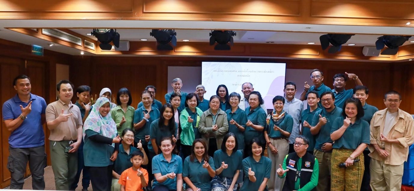 A group of people standing in front of a screen

Description automatically generated