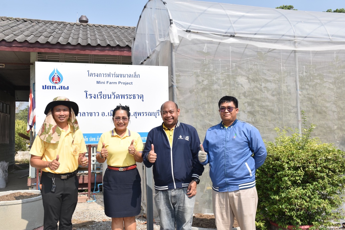 A group of people standing in front of a sign

Description automatically generated