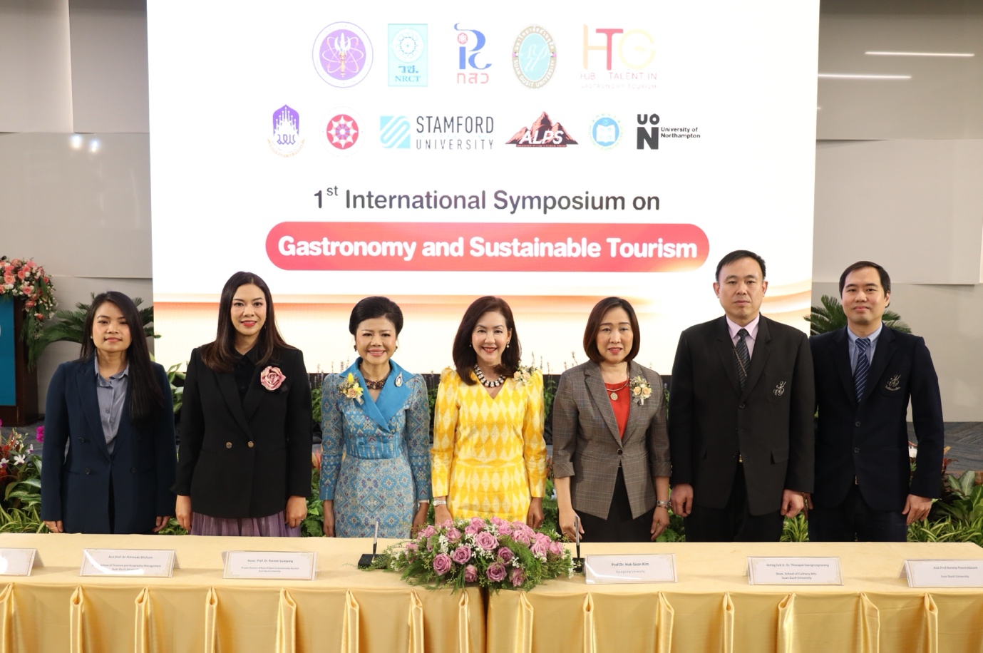 A group of people standing in front of a table

Description automatically generated