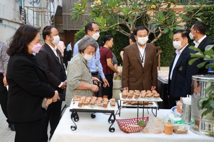 A group of people wearing face masks standing next to a table with food

AI-generated content may be incorrect.