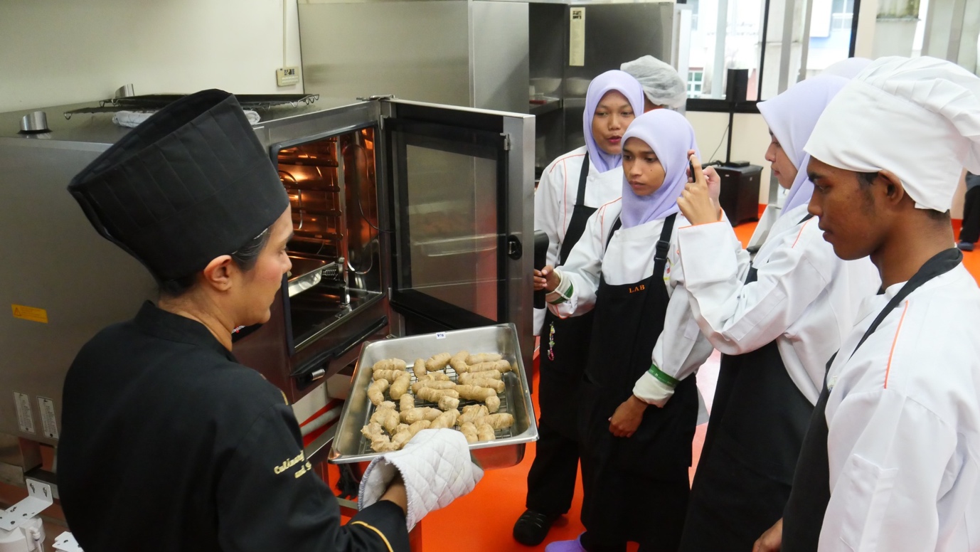 A group of women in a kitchen

Description automatically generated