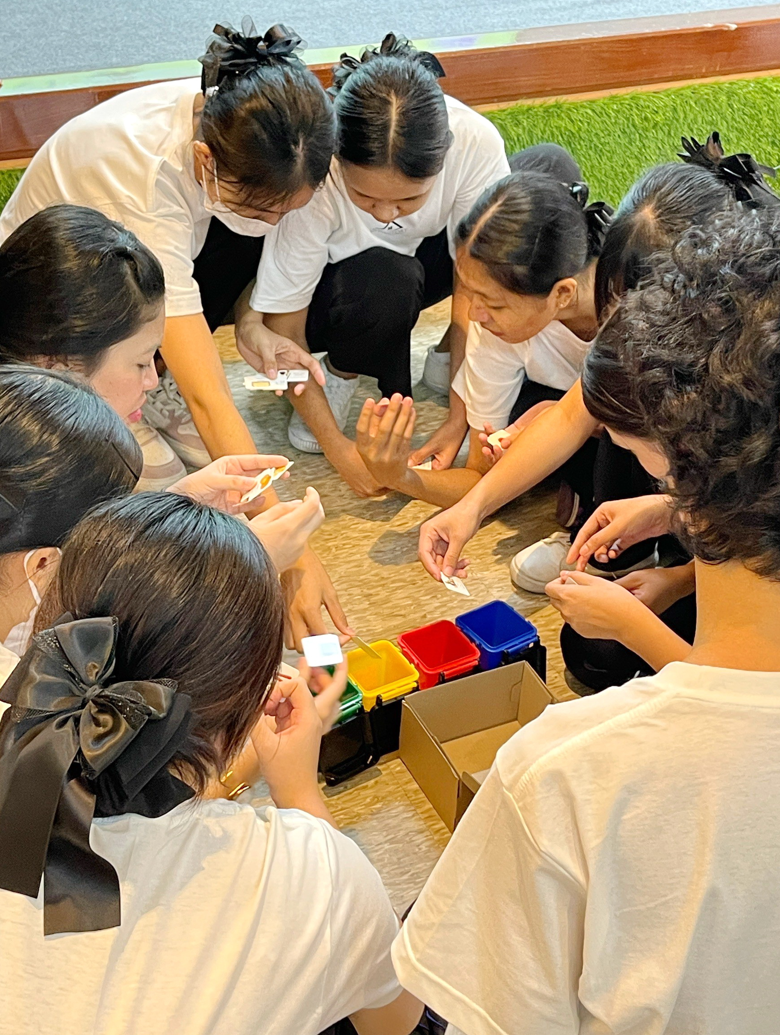 A group of women sitting on a floor
AI-generated content may be incorrect.