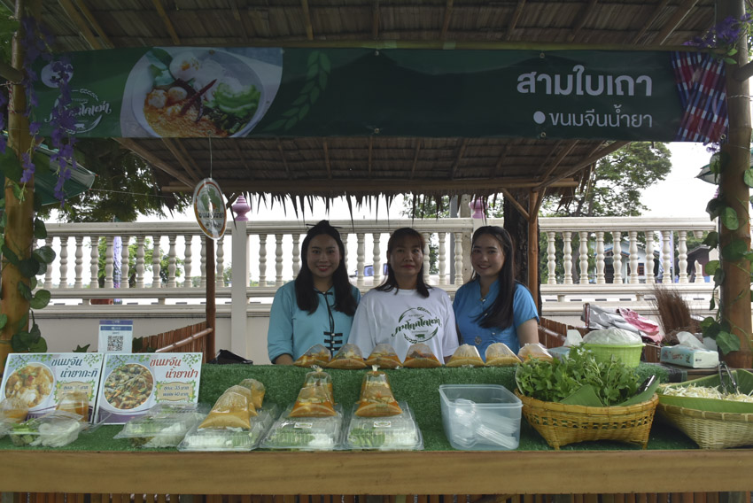 A group of women standing behind a table with food
Description automatically generated