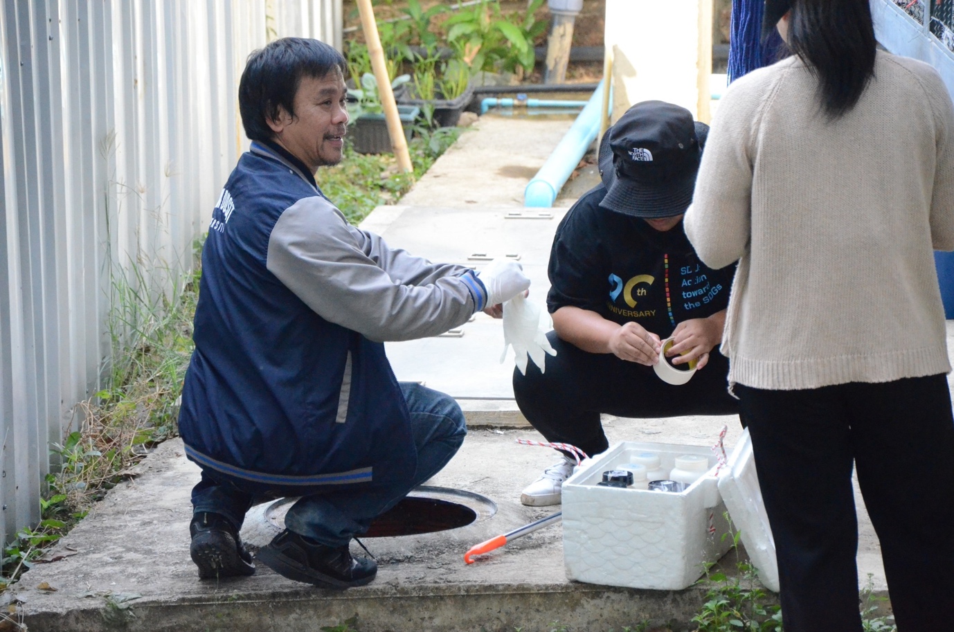 A person kneeling on the ground with a person in gloves

Description automatically generated