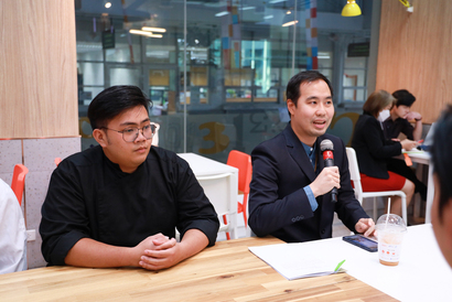 A person sitting at a table with a microphone

Description automatically generated