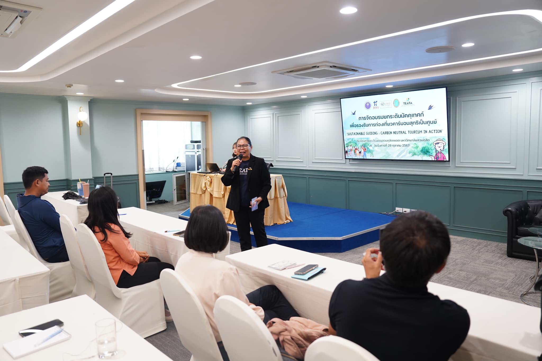 A person speaking to a group of people

Description automatically generated