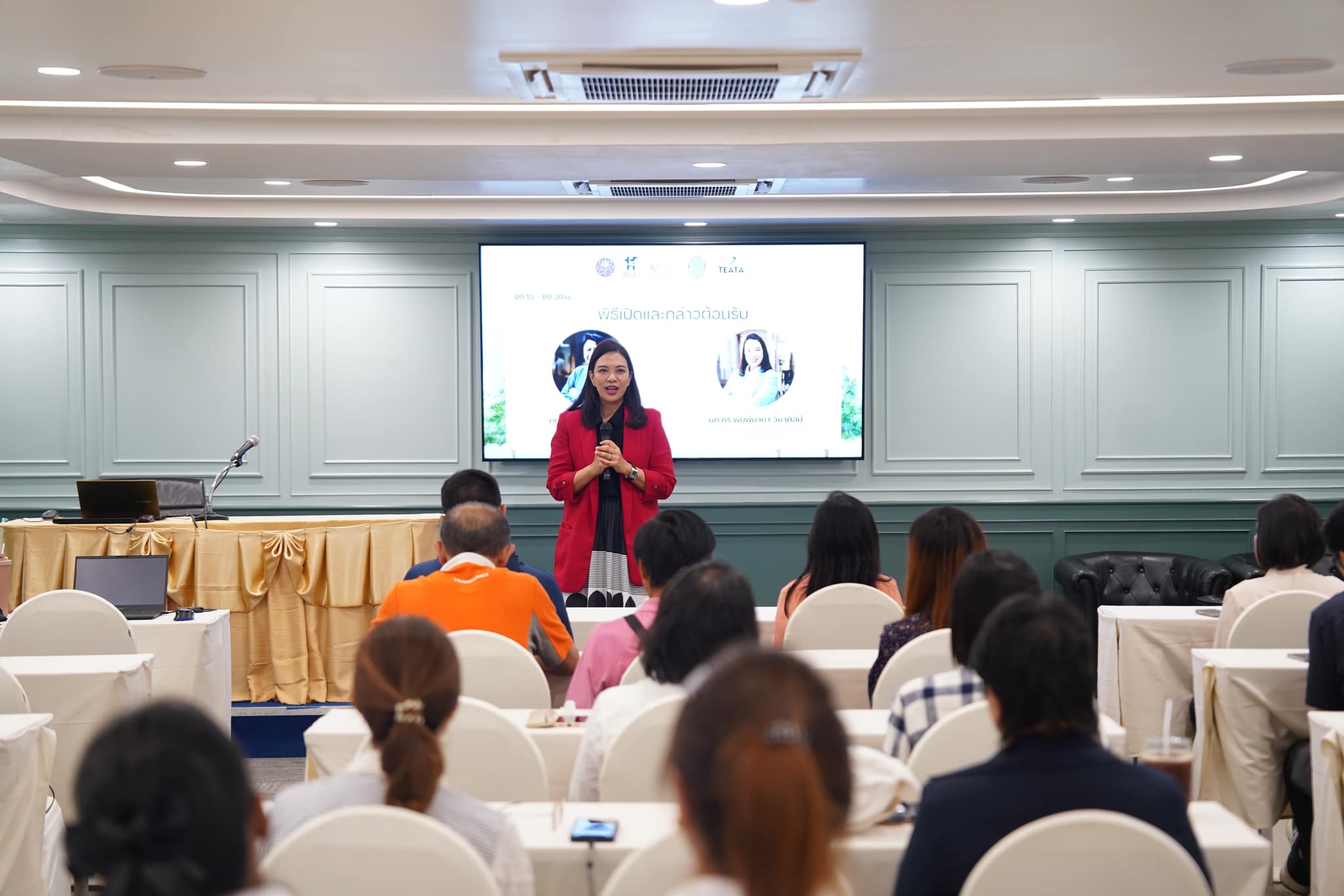 A person standing in front of a group of people

Description automatically generated