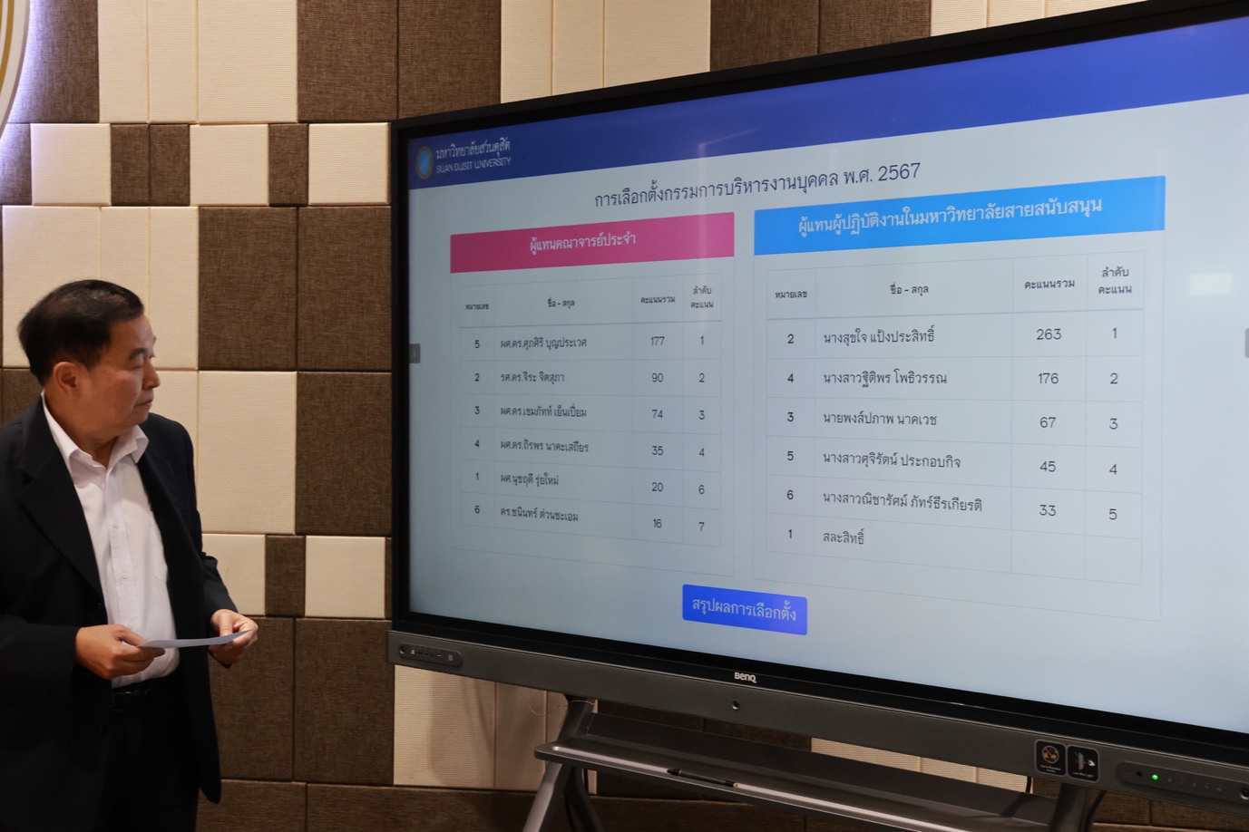 A person standing in front of a large screen
Description automatically generated