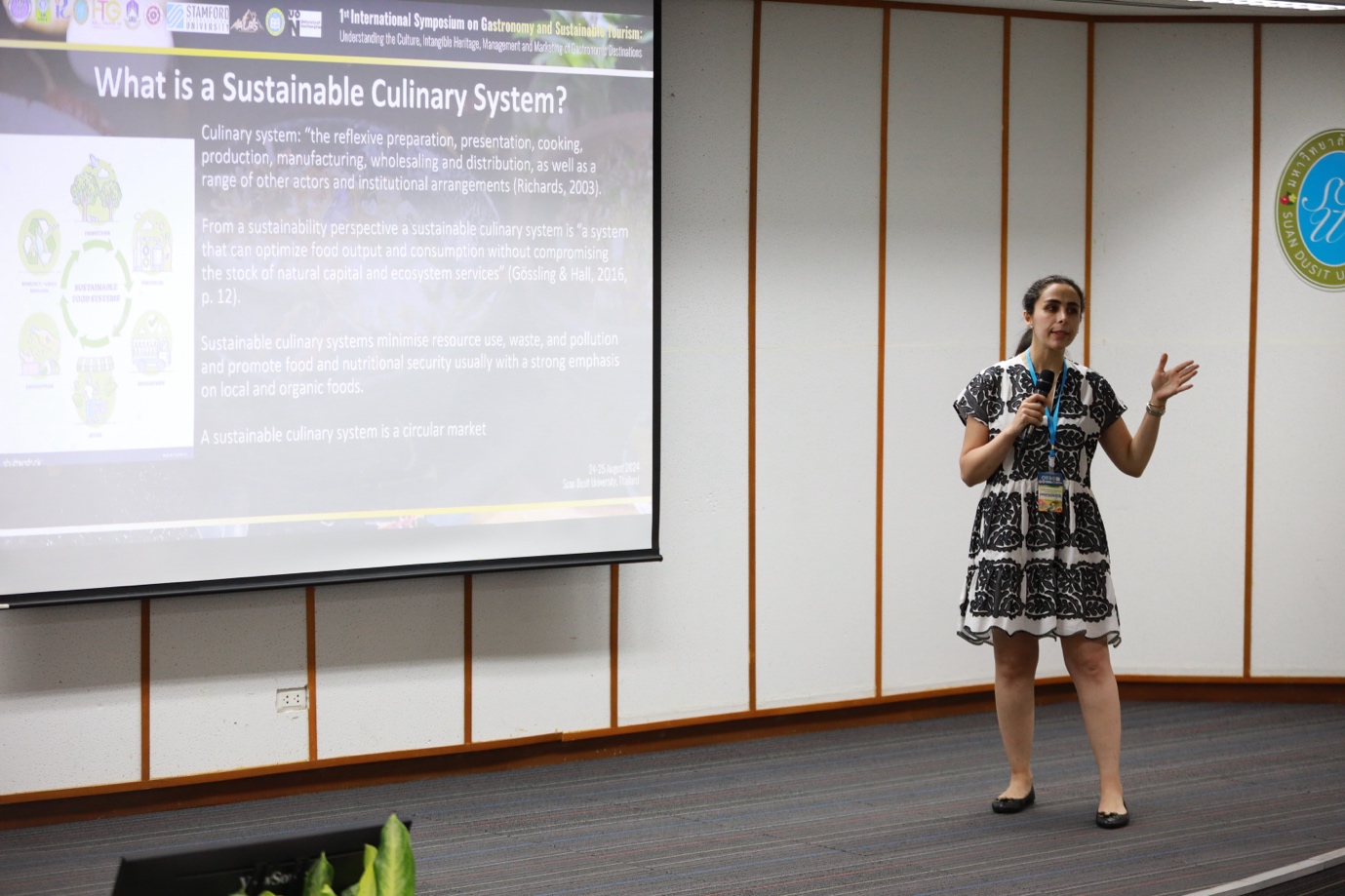 A person standing in front of a projector screen
Description automatically generated