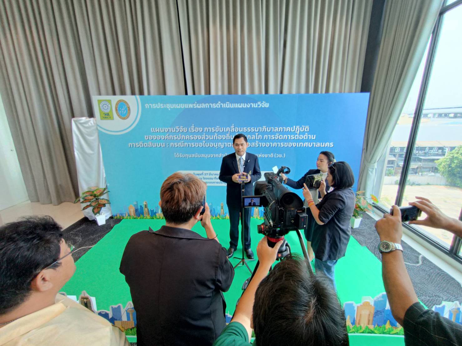 A person standing in front of a stage with a microphone
Description automatically generated