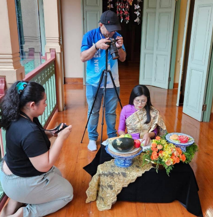 A person taking a picture of a person sitting on a table with a camera

AI-generated content may be incorrect.
