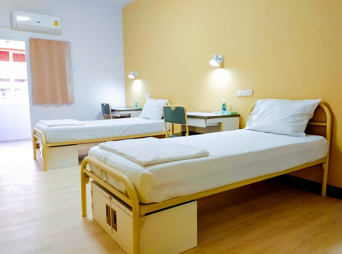 A room with two beds and desks

AI-generated content may be incorrect.