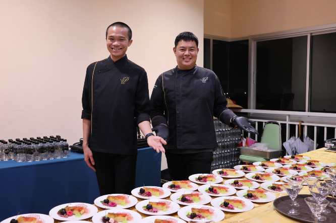 Two men standing next to plates of food
AI-generated content may be incorrect.